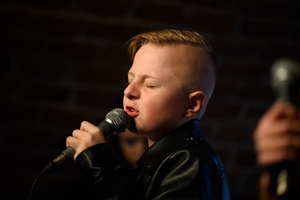Koncert S.M.ROCK: na scenie uczeń śpiewający piosenkę