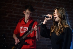 Koncert S.M.ROCK: na scenie śpiewająca uczennica i grający na gitarze uczeń