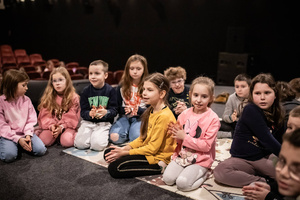 Filmowe ferie w kinie Marzenie - Na fotografii widzimy grupę dzieci na scenie przed ekranem, podczas animacji poprzedzających projekcje filmowe w ramach cyklu "Filmowe ferie".