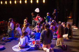 Filmowe ferie w kinie Marzenie - Na fotografii widzimy grupę dzieci na scenie przed ekranem, podczas animacji poprzedzających projekcje filmowe w ramach cyklu "Filmowe ferie".