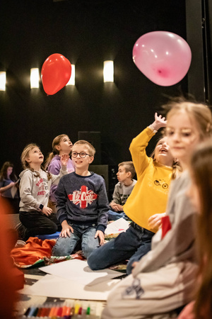 Filmowe ferie w kinie Marzenie - Na fotografii widzimy grupę dzieci na scenie przed ekranem, podczas animacji poprzedzających projekcje filmowe w ramach cyklu "Filmowe ferie".