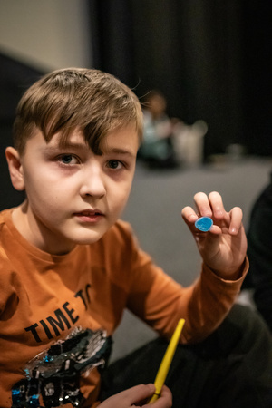 Filmowe ferie w kinie Marzenie - Na fotografii widzimy grupę dzieci na scenie przed ekranem, podczas animacji poprzedzających projekcje filmowe w ramach cyklu "Filmowe ferie".