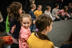 Filmowe ferie w kinie Marzenie - Na fotografii widzimy grupę dzieci na scenie przed ekranem, podczas animacji poprzedzających projekcje filmowe w ramach cyklu "Filmowe ferie".