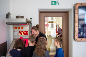 Naukowe Ferie w Pasażu Odkryć - Na zdjęciu przedstawieni są uczestnicy – dzieci i młodzież – zaangażowani w aktywności edukacyjne w różnych pracowniach naukowych, takich jak chemiczna, stolarska, planetarium oraz informatyczna. Widoczne są sceny, gdzie uczą się i przeprowadzają eksperymenty pod nadzorem instruktorów.