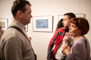 Wernisaże dzień po dniu: Paweł Wadas / Krzysztof Madej - Zdjęcie z otwarcia wystawy w Galerii TCK. Przedstawia uczestników wernisażu, skupionych w oglądaniu prac i rozmowach z autorami. Fotografia ukazuje dynamiczną atmosferę wydarzenia.