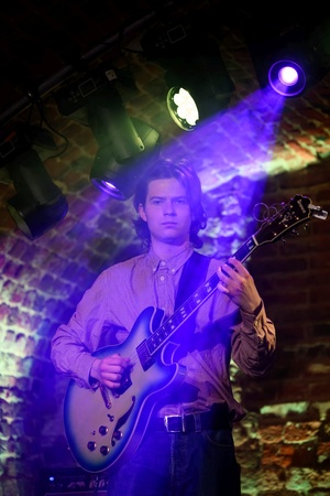 Koncert jazzowy: Tomasz Chyła Quintet - Zdjęcie sceny z koncertu Tomasz Chyła Quintet, pokazujące zaangażowanych muzyków. Tomasz Chyła gra na skrzypcach, w tle pozostali muzycy na różnych instrumentach. Scena jest dynamicznie oświetlona, co dodaje energii występowi.