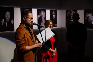 Wernisaż wystawy fotografii Inki Rosochy "Nie mogę na to patrzeć" - Na pierwszym planie Marcin Dąbek, w tle Inka Rosocha