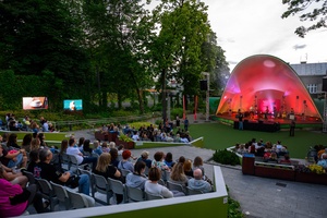 38. TNF - Dzień 1 (31.05.2024) - Amfiteatralna publiczność podczas koncertu Tomka Ziętka w tle na scenie Tomek Ziętek z zespołem