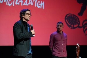 38. TNF - Dzień 2 (1.06.2024) - Na scenie reżyser filmu "Skąd dokąd" Maciej Hamela zapraszający widzów na film, w tle Kuba Armata