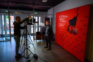 38. TNF - Dzień 3 (2.06.2024) - Mikołaj Trzaska na tle ścianki festiwalowej w holu Marzenia