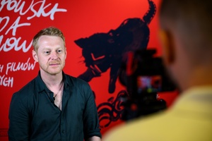 38. TNF - Dzień 5 (4.06.2024) - Aktor Cezary Łukaszewicz na tle ścianki 38. TNF w holu Marzenia