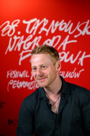 38. TNF - Dzień 5 (4.06.2024) - Aktor Cezary Łukaszewicz na tle ścianki 38. TNF w holu Marzenia