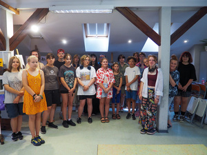 Wakacje z otwARTą: Kurs rysunku i malarstwa - Uczestnicy podczas wystawki podsumowującej warsztaty - zdjęcie grupowe.