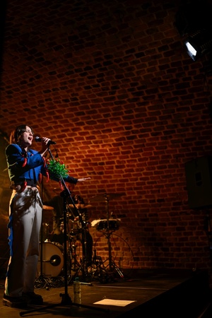 Koncert: Ania Szlagowska - Wokalistka Ania Szlagowska występuje z zespołem muzycznym podczas koncertu.