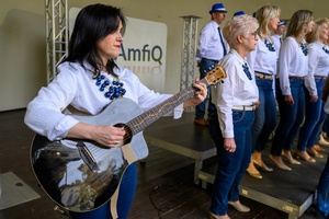 Koncert Chóralne Majówki: Chór Fox Vox - Na pierwszym planie na amfiteatralnej scenie gitarzystka i chór Fox Vox