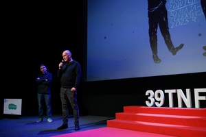 39. TNF: Dzień 5 (3.06.2025) - Na scenie Marzenia reżyser filmu "Wróbel" Tomasz Gąssowski zaprasza widzów na projekcję. W tle Kuba Armata