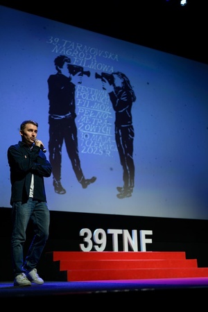 39. TNF: Dzień 7 (5.06.2025) - Na scenie Marzenia Kuba Armata zapowiadający przed publicznością projekcję konkursową filmu "To nie mój film"