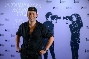 39. TNF: Gala Wręczenia Nagród (7.06.2025) - W hallu kina na tle ścianki 39. TNF aktor Mikołaj Matczak ze statuetką Kamerzysty