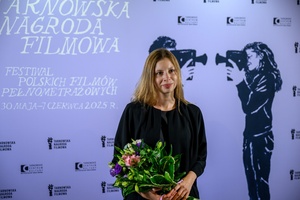 39. TNF: Gala Wręczenia Nagród (7.06.2025) - W hallu kina na tle ścianki 39. TNF reżyserka Monika Majorek z kwiatami