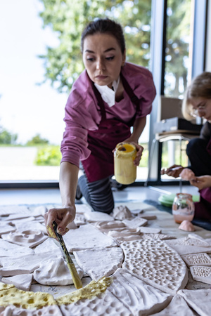 „Kompozycja miejska” - warsztaty ceramiczne - Uczestnicy warsztatów podczas szkliwienia