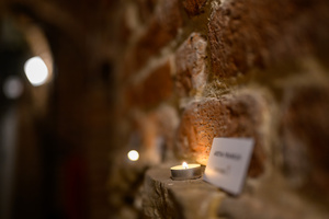 Koncert: Zaduszki - Damian Ukeje - Element scenografii - etykiety z nazwiskami nieżyjących artystów oświetlone świeczkami.