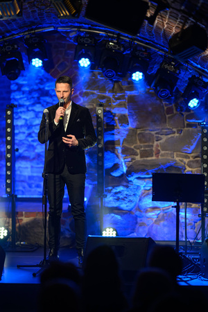 Koncert: Agnieszka Hekiert - Magia Świąt - Konferansjer Sebastian Szafarz zapowiadający koncert na scenie.