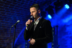 Koncert: Agnieszka Hekiert - Magia Świąt - Konferansjer Sebastian Szafarz zapowiadający koncert na scenie.