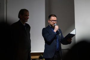 Wystawa: Rozważania nad istotą czasu - Marcin Dąbek podczas przemowy na otwarciu, obok autor wystawy Marek Kucharczyk.