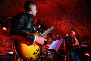 Koncert: LNSD Quartet - Gabriel Niedziela gra na gitarze, w tle Szymon Łukowski.